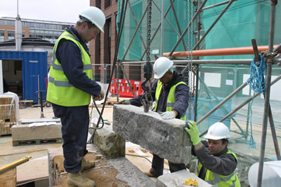 Lowering a second course stone into place